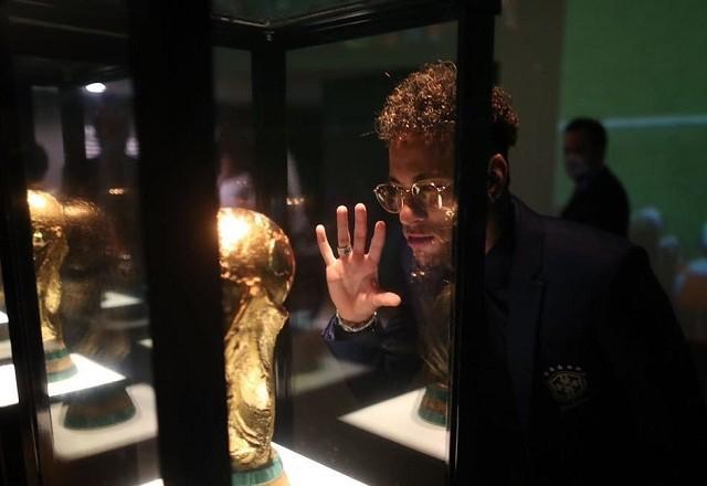 Neymar olhando a taça da Copa do Mundo
